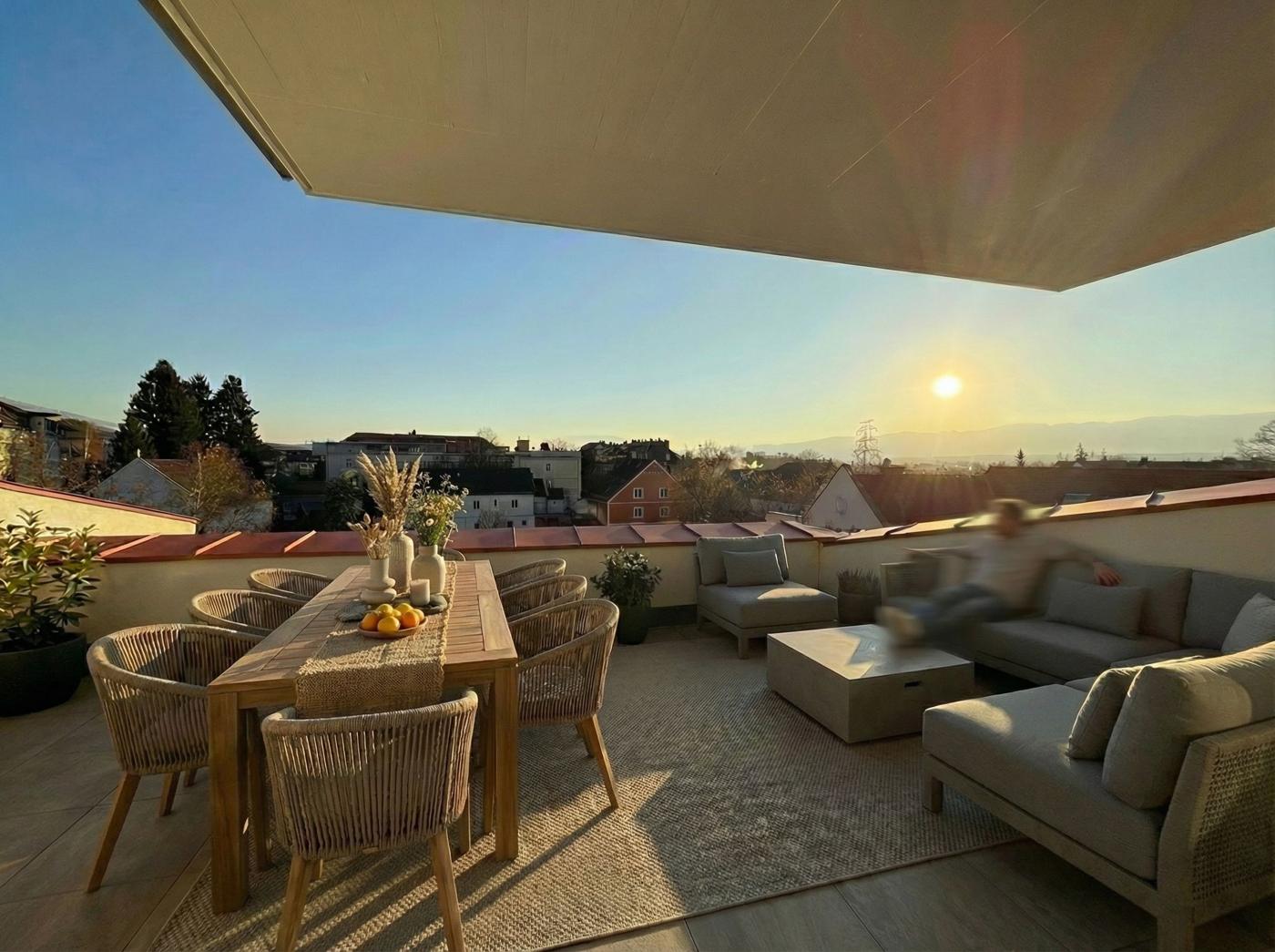 Moserhof, Dachterrasse mit Sitzgruppe bei Sonnenuntergang
